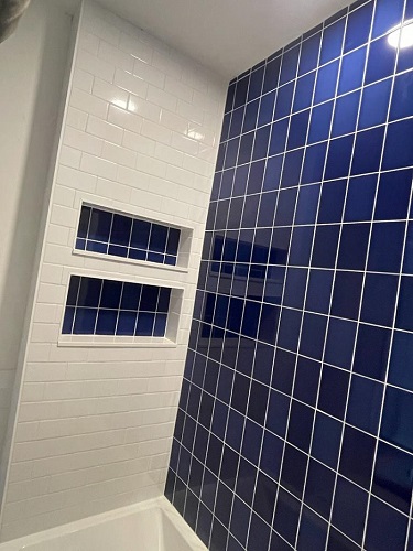 Newly installed wall tiles and niche in a bathroom.